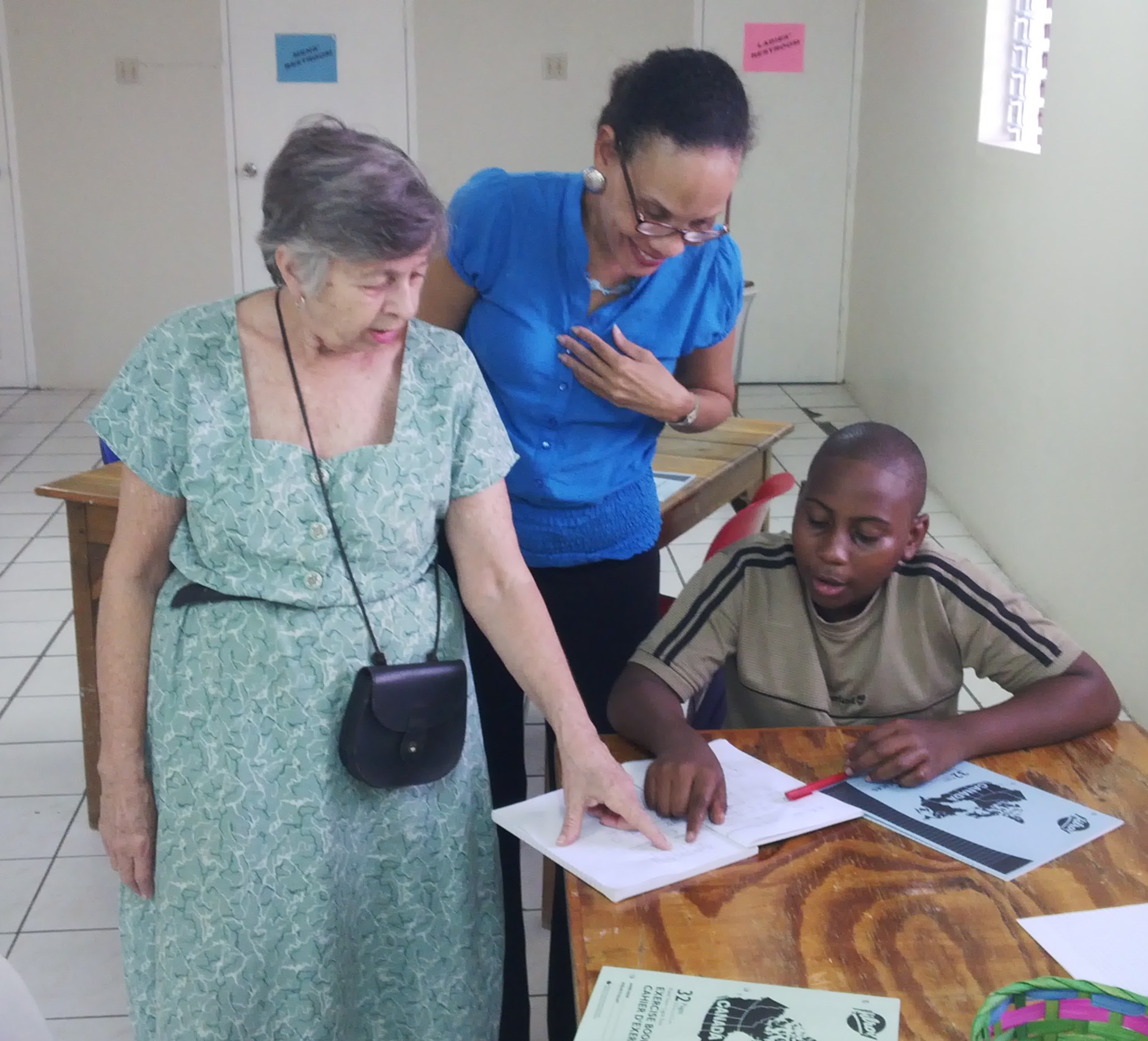 Volunteer, Sally Fulton and Coordinator of the Centre, Donna Muirhead (centre), assists student, Noah.